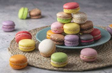 a plate that has a bunch of different colored macaroons on it